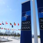 NATO’s Stark Warning to Ukraine – A Harsh Reality Exposed NATO flags and banners under clear sky.