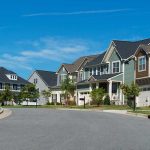 Shocking Unexpected Cause of Cognitive Decline – It’s in Our Homes Suburban street with colorful, modern houses.