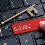Unwavering High-Stakes Ban Creates Global Fallout Banned button on keyboard with a skeleton key.