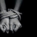 Major Human Smuggling Operation Crushed – HIdden Details Revealed Hands bound with rope against a dark background.