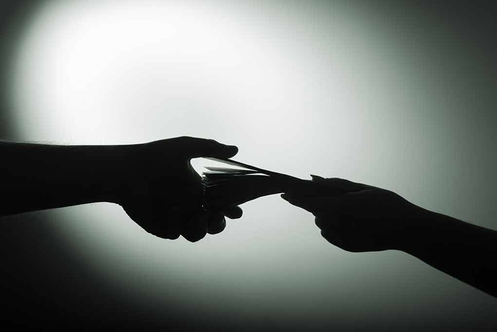 Silhouette of hands exchanging money