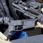 Stunning Discovery – Who Really Stops Active Shooters? Person assembling a rifle with gloved hands.