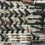 Wall display with handguns and rifles for sale.