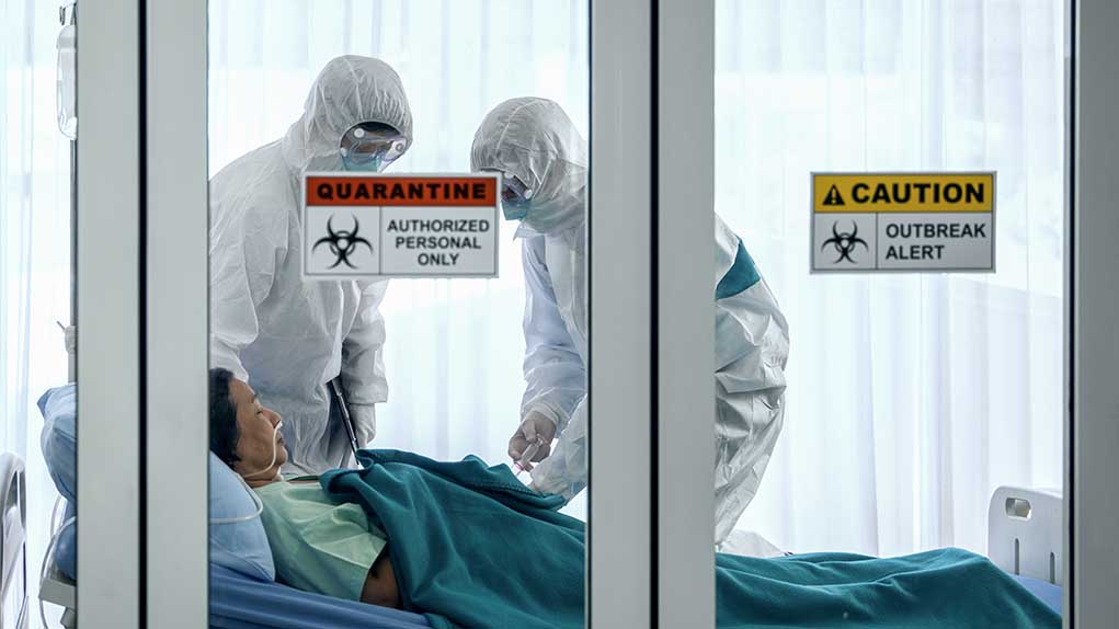 1647350797 featured image Healthcare workers in protective gear in quarantine room.