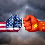 Two fists painted as USA and China flags