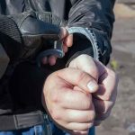 9 Men in Chains – The Dark Secret Behind a Routine Police Call Gloved officer handcuffing a person's hands outdoors