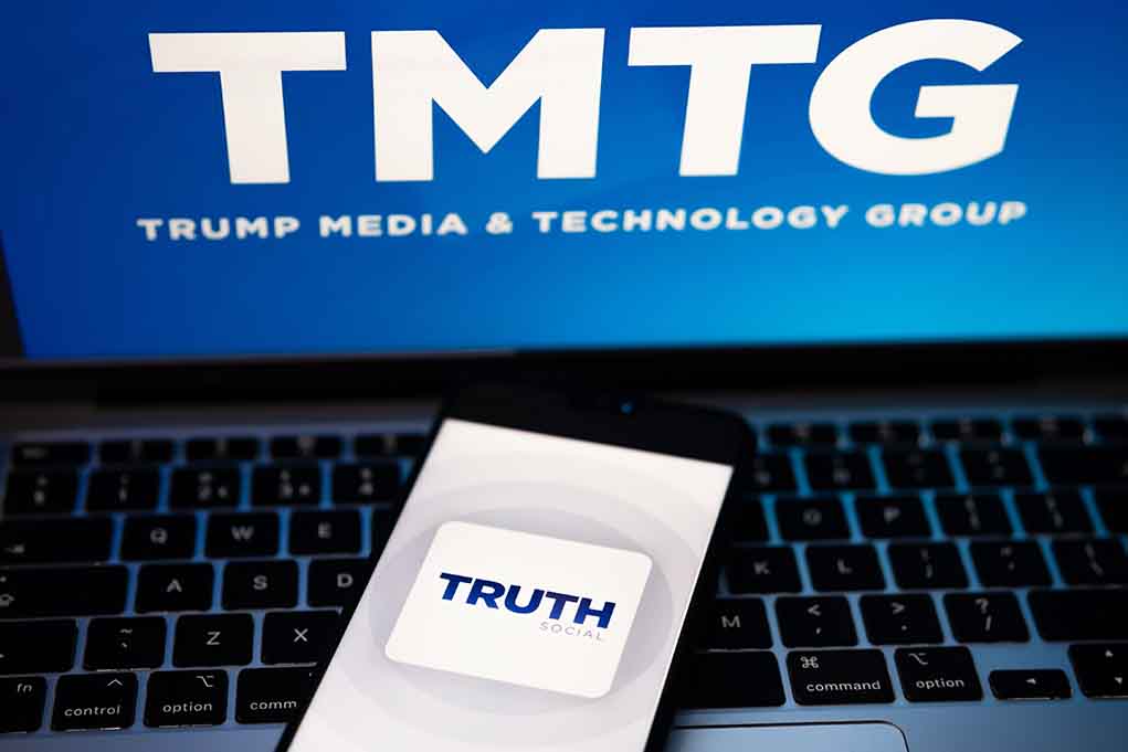 "TMTG and Truth Social logos on screen and phone."