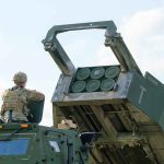 Soldier with military vehicle and missile launcher.
