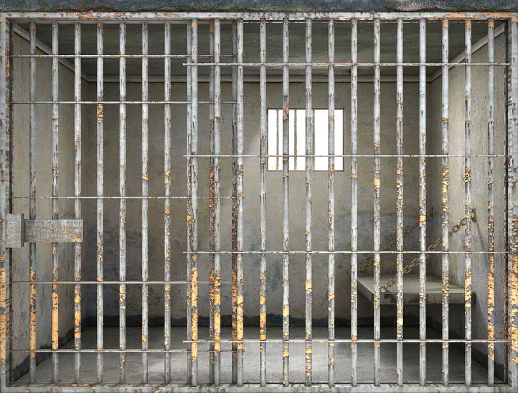 Empty rusty prison cell with a small window.