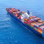 Cargo ship carrying colorful containers in open sea