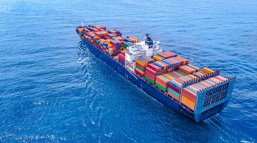 Cargo ship carrying colorful containers in open sea