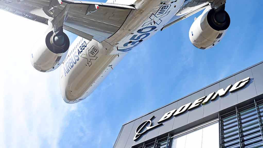 Airbus plane flying over Boeing building.