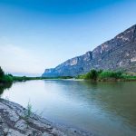 River with mountains and greenery in the background