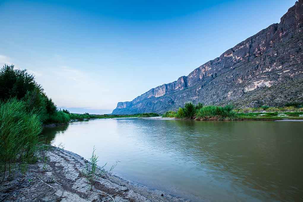 River with mountains and greenery in the background