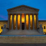 Illuminated courthouse building at dusk with columns