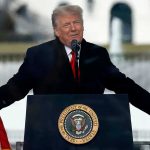 Trump’s Stunning Weapon for a Dying Town Trump speaking at a podium with microphones