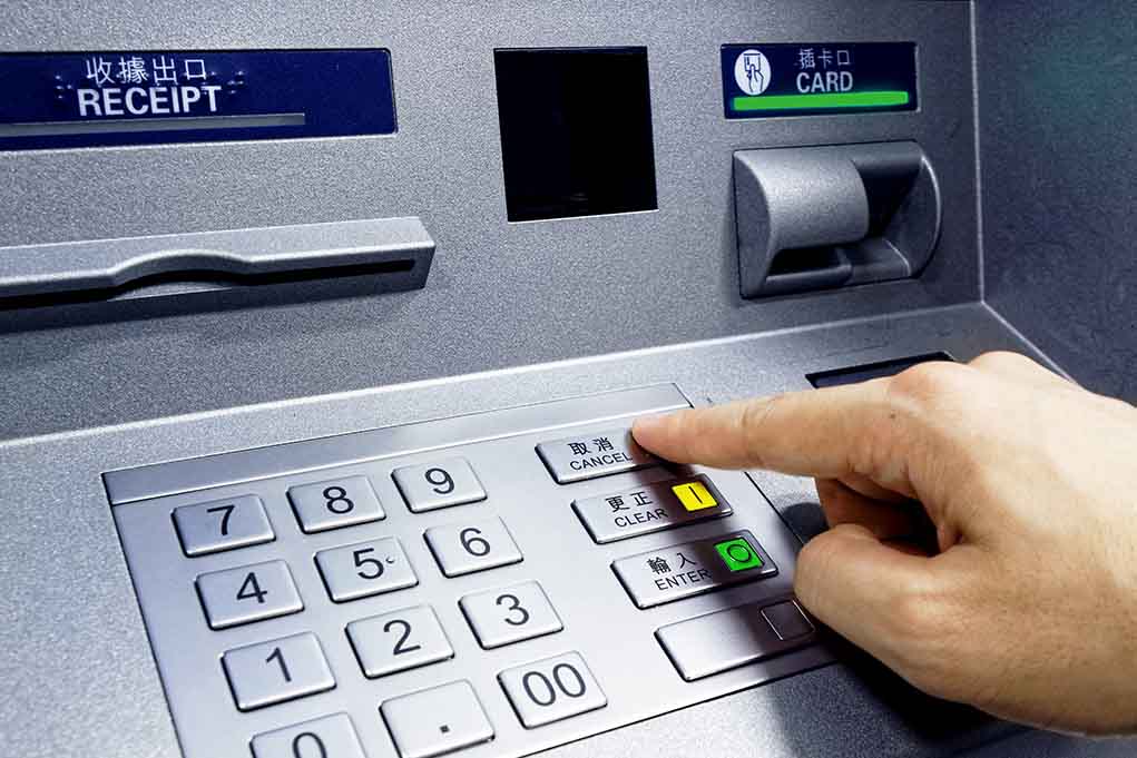 Person pressing button on an ATM keypad