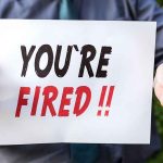 Person holding you're fired sign