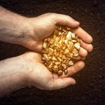 Critical Minerals Found — But There’s a Catch Hands holding gold nuggets over dark background
