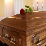 Medical Gaslighting — The Outrageous Killer Wooden coffin with red rose on top