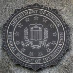 Fiery Exchange: Dean and Patel Battle Over FBI’s Alleged Bias FBI seal on granite wall displaying department motto
