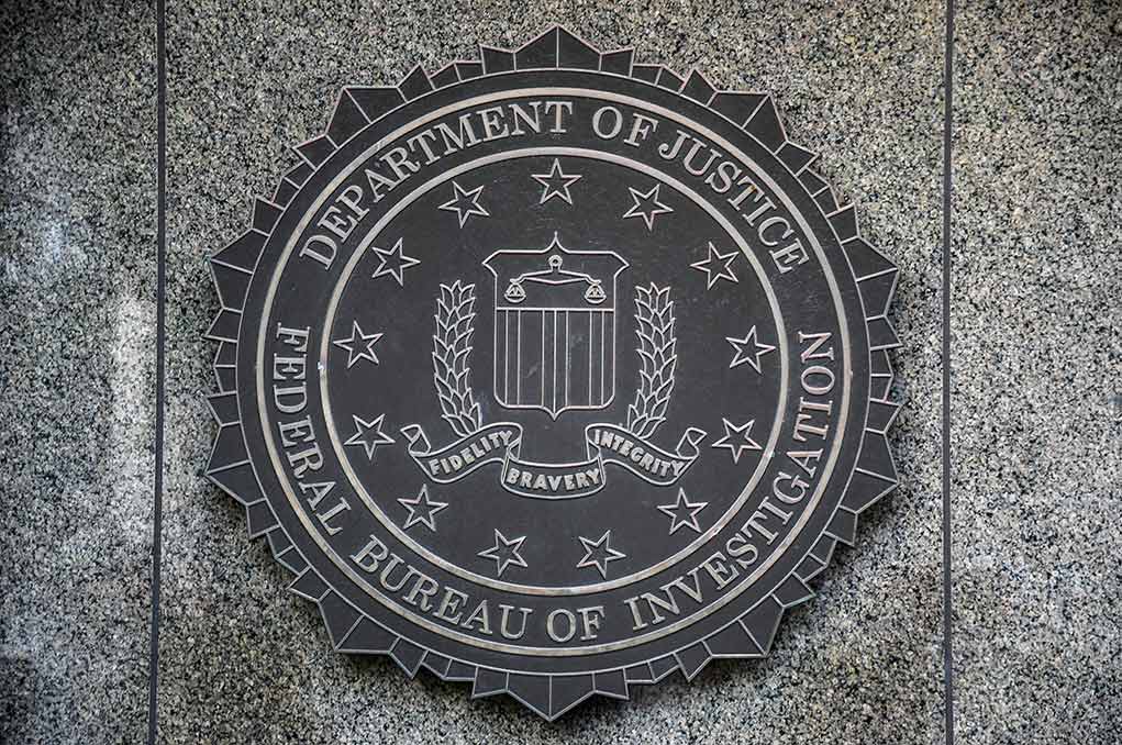FBI seal on granite wall displaying department motto