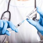 ACLU DECLARES WAR Over School Vax Rule Doctor filling syringe with vaccine from vial