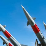 Missiles pointing upwards against a clear sky