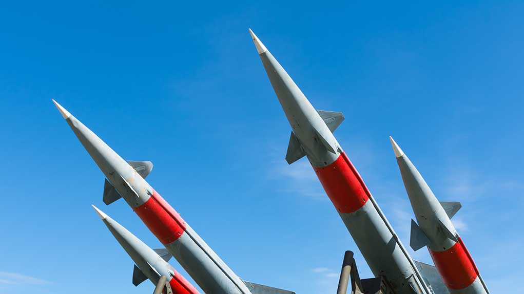 Missiles pointing upwards against a clear sky