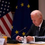Biden Cover-Up Explodes — Jill Dragged In Man seated at table with flags in background