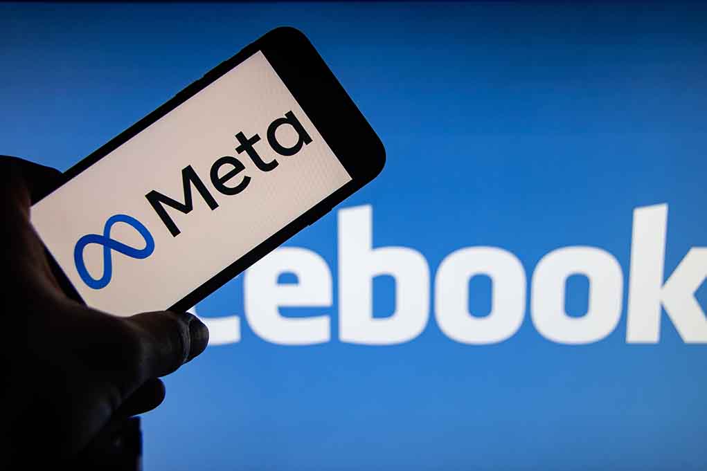 Meta logo on phone Facebook background display
