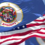 Minnesota state flag with American flag in background
