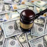 FTC Demands Publisher Refund Millions Over Misleading Marketing Tactics Gavel on pile of hundred dollar bills