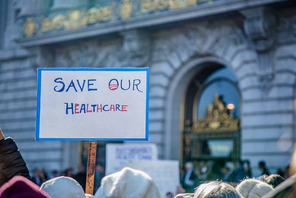 Sign reading Save Our Healthcare at protest