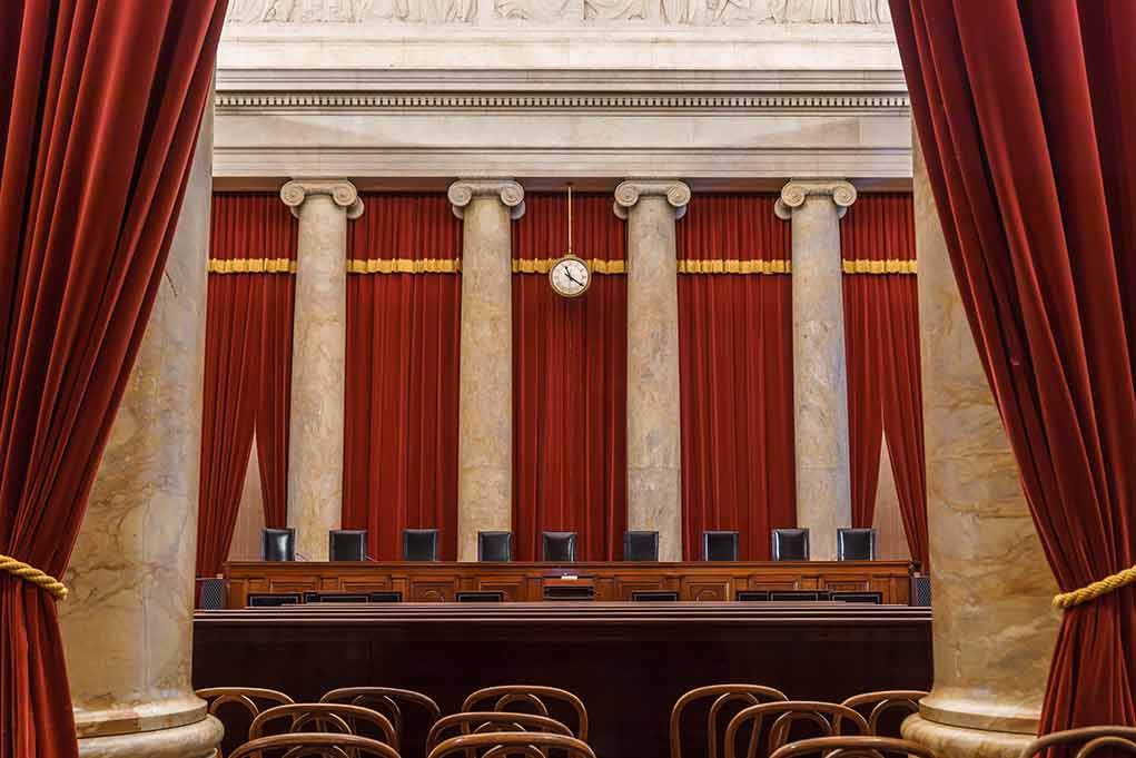 Empty courtroom with columns red curtains and chairs