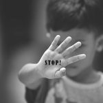 The Role of Subcontracting in Alleged Child Labor Violations at Tyson Foods Child holding up hand with STOP written on palm