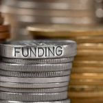 Antisemitism Firestorm—Federal Funds at Risk Stack of coins labeled funding with other coins stacks