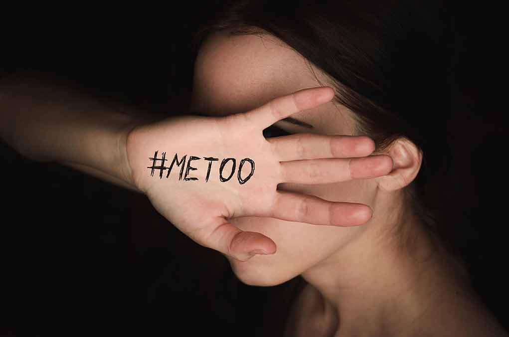 Hand with #MeToo covering face