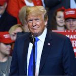 TRUMP STRIKES Back — Migrant Deal Unnerves Critics Person at a rally with Make America Great Again signs