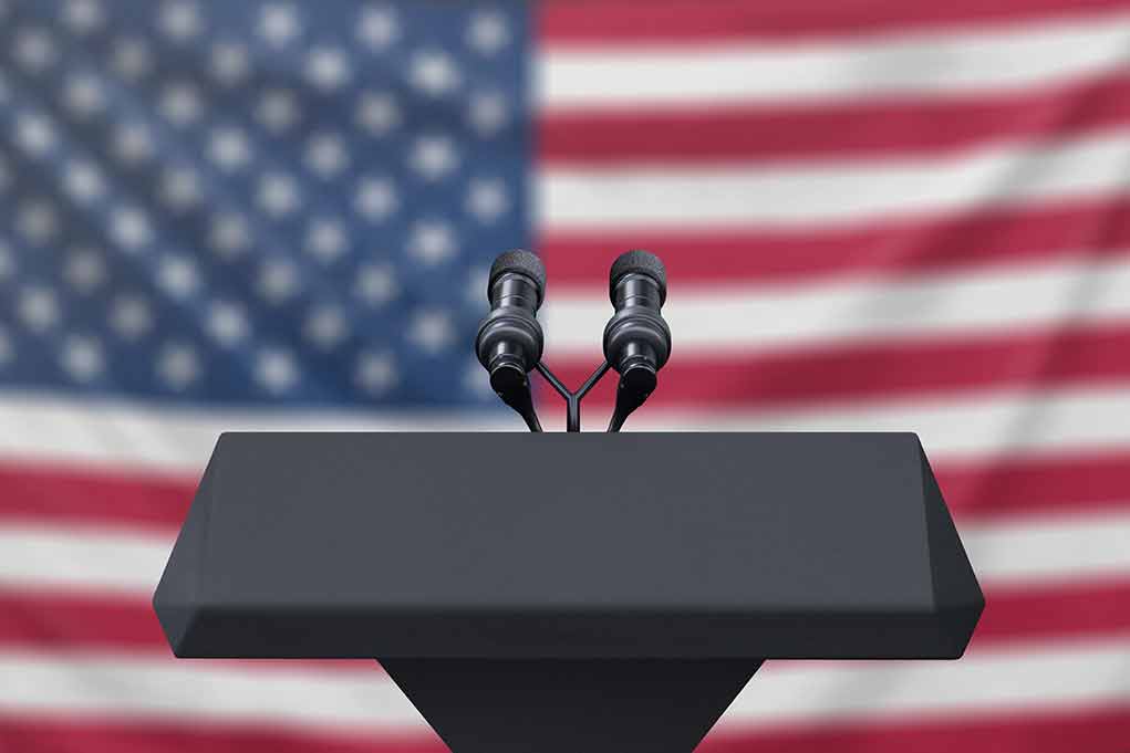 Podium with microphones American flag background