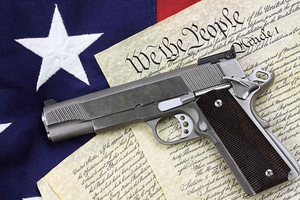 Gun on US Constitution and flag
