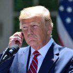 Zelenskyy Sounds Alarm: Only Trump Can Stop Russia Man in a suit adjusting an earpiece