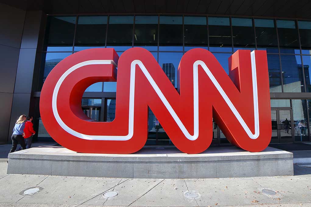 Large red CNN sign outside building entrance