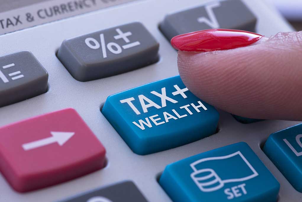 Finger pressing calculator tax and wealth button