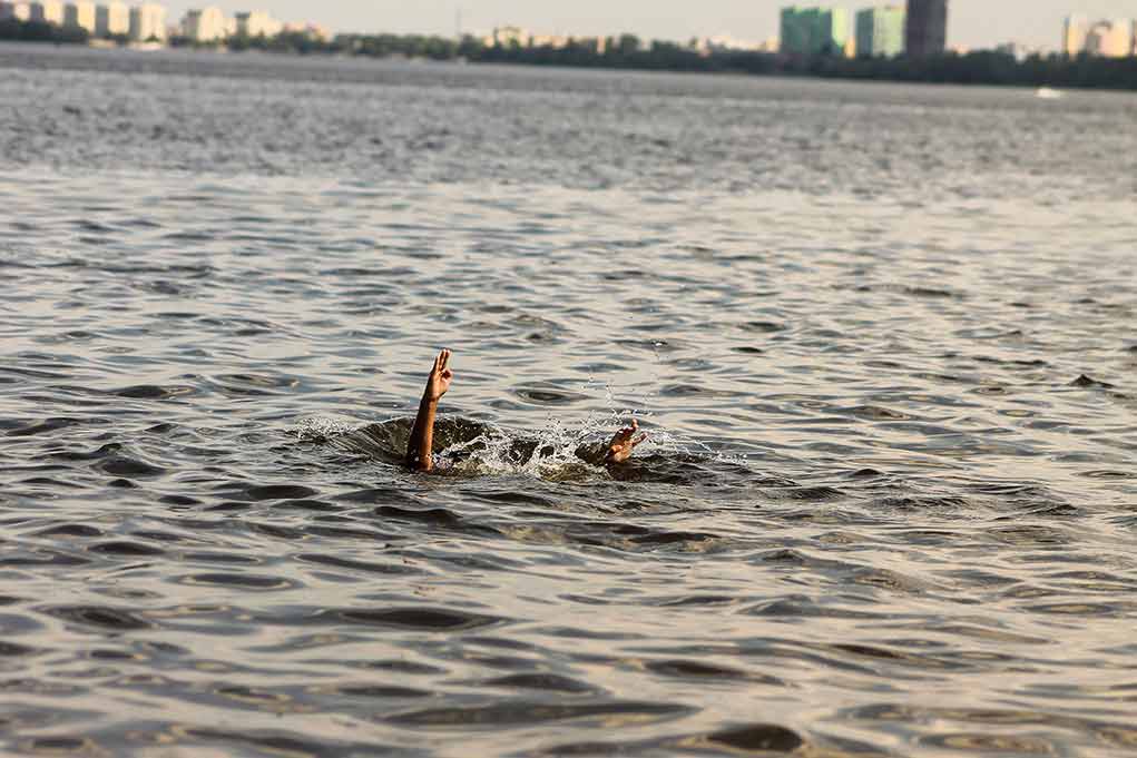 Persons hand reaching out from the water