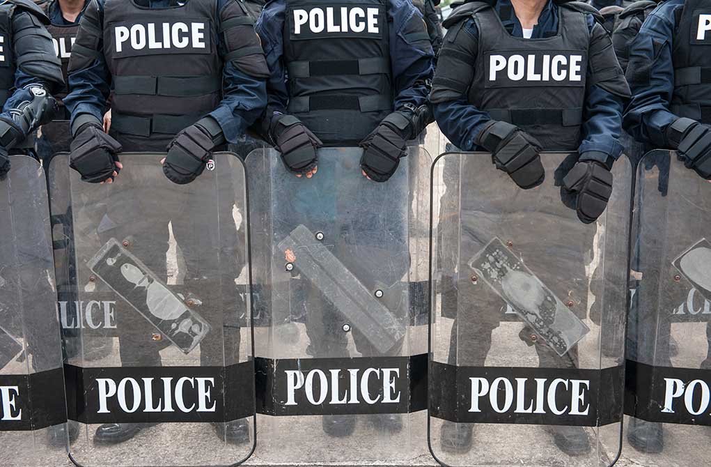 Police officers in riot gear holding shields