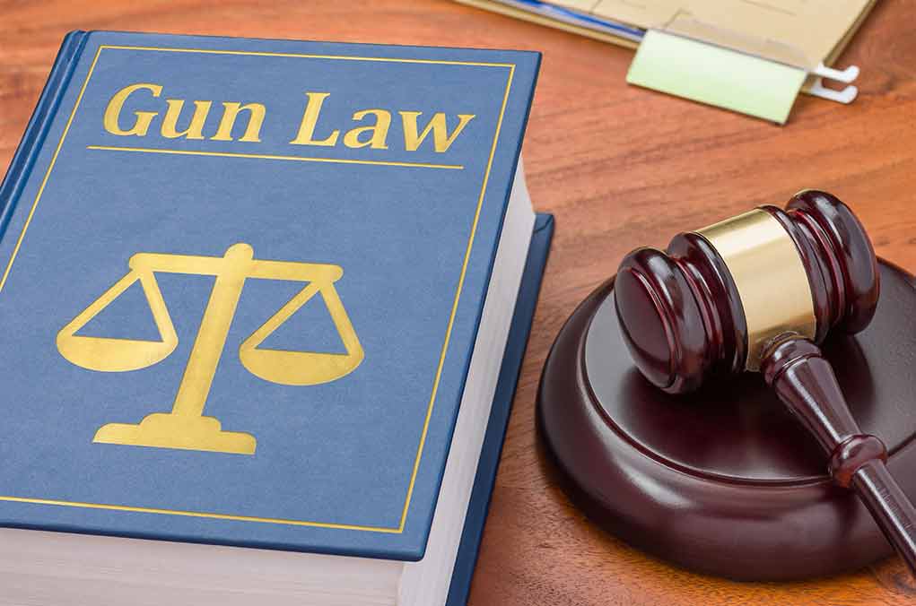 Gun Law book and gavel on wooden desk