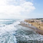 Crowded beach with waves and people enjoying sun