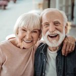 Elderly couple smiling together outdoors