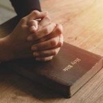 TRUMP UNLEASHES Religious Freedom Bombshell Hands praying on a Bible